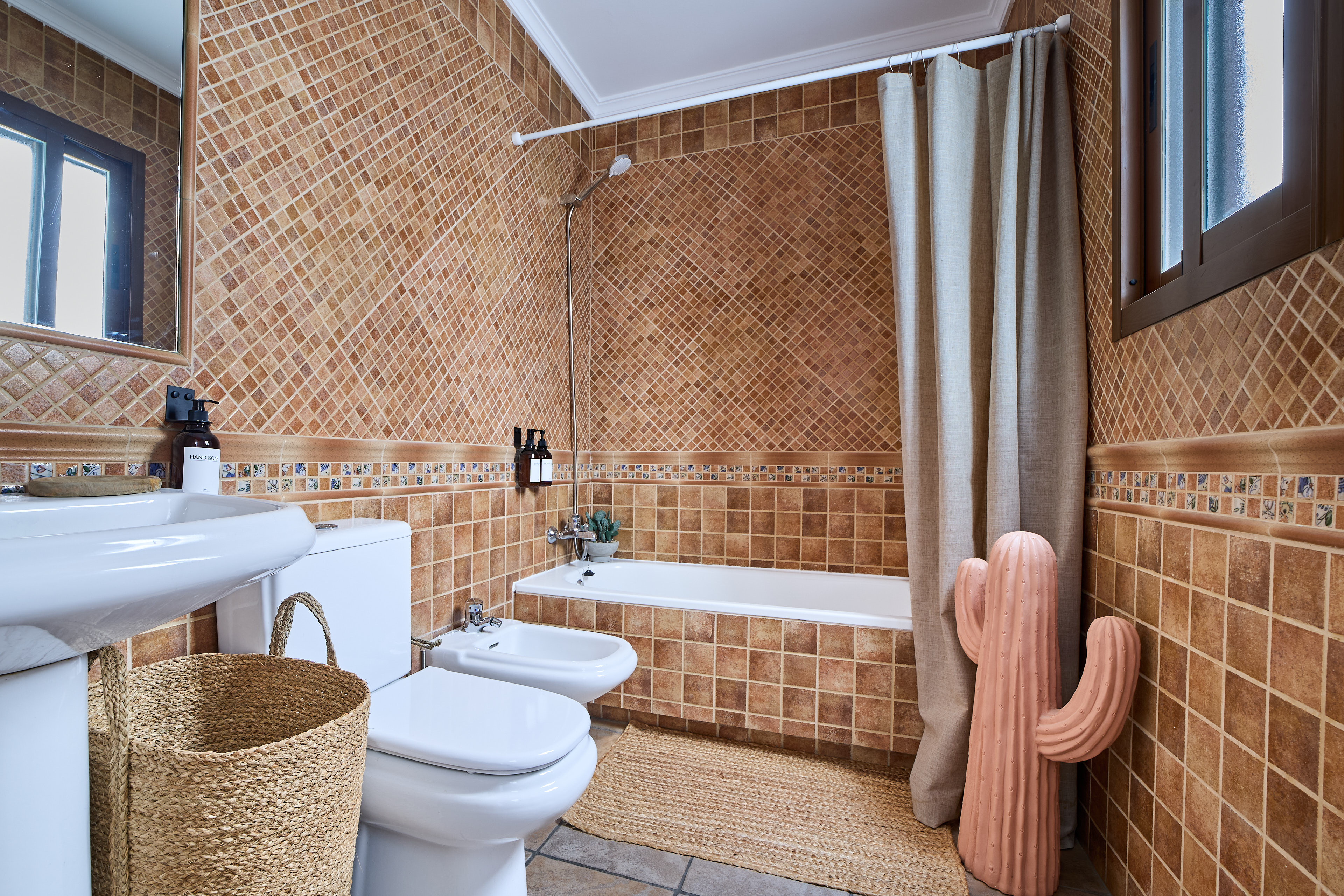 Casa Wanda bathroom detail with warm tile and fresh flowers